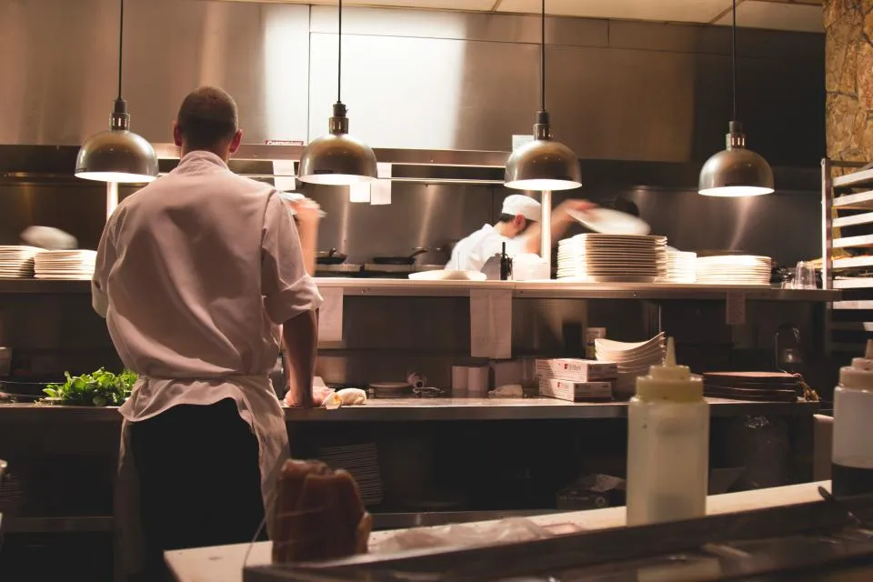 La brigade au travail dans la cuisine, sous les lampes